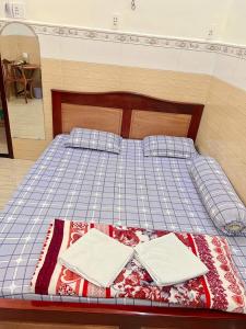 a bed with two white towels on top of it at Nhà nghỉ phương nam in Ấp Rạch Mẹo