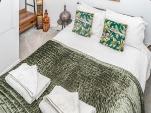 una camera con letto verde e bianco con cuscini di Camoor Cottage a Hornsea