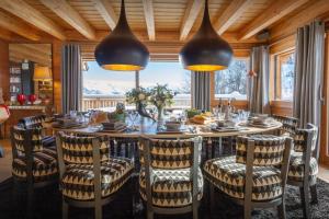 Un comedor con una mesa grande y sillas. en Chalet Temaïa - OVO Network, en La Toussuire