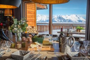 a dining table with a view of snow covered mountains at Chalet Temaïa - OVO Network in La Toussuire