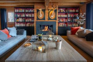 Una sala de estar con un sofá y una chimenea. en Chalet Temaïa - OVO Network, en La Toussuire