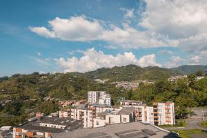 Blick auf eine Stadt mit Gebäuden und Bergen in der Unterkunft El Mirador De Castilla in Manizales