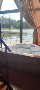 una vasca da bagno in una stanza con una grande finestra di Recanto do lago a Itati