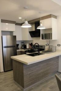 a kitchen with a sink and a refrigerator at Nuevo apartamento en Stanza in San Pedro Sula