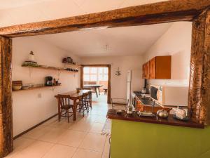 a kitchen with a counter and a table with chairs at Casa 2 - Estrela Dalva in Farol de Santa Marta