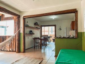 a room with a kitchen and a table with a mirror at Casa 2 - Estrela Dalva in Farol de Santa Marta
