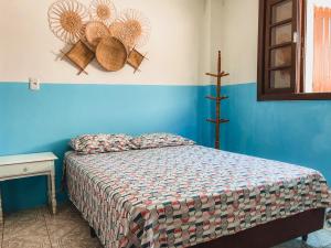 a bedroom with a bed and a blue wall at Casa 2 - Estrela Dalva in Farol de Santa Marta