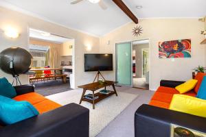 een woonkamer met 2 banken en een tv bij Retro 4 bedroom home, warm and welcoming, quiet location in Porirua