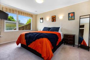 a bedroom with a bed and a large window at Retro 4 bedroom home, warm and welcoming, quiet location in Porirua