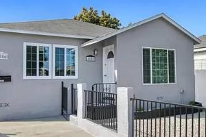 a white house with a black fence at Spacious 3Bdr Home close to Manhattan Beach in Lawndale