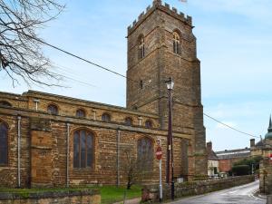 a large brick church with a tall tower at Racing Retreat in Towcester