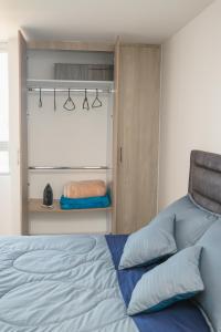 ein Schlafzimmer mit einem Bett mit blauen Kissen in der Unterkunft El Mirador De Castilla in Manizales
