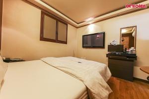 a hotel room with a bed and a flat screen tv at Coups Hotel in Seoul