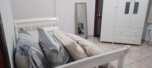 a row of pillows on a bed in a room at Quarto Due na Sakura House in Indaiatuba