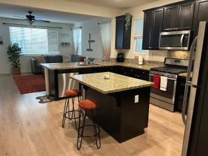 a kitchen with black cabinets and a kitchen island with bar stools at 3238 Correll Way in Rancho Cordova