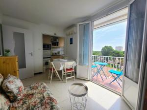 a living room with a couch and a table and a balcony at Appartement Argelès-sur-Mer, 2 pièces, 4 personnes - FR-1-309-386 in Argelès-sur-Mer