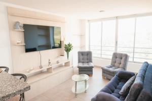 un soggiorno con divano, sedie e TV di El Mirador De Castilla a Manizales