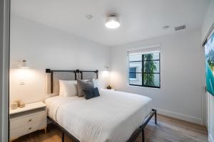 une chambre avec un grand lit blanc et une fenêtre dans l'établissement Lux Retreat By Renzzi, à Miami