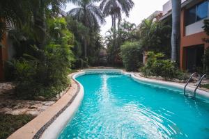 a swimming pool in a resort with blue water at Casa Serena in Cancún