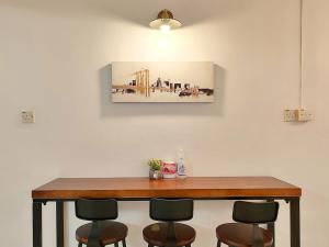 a dining room table with chairs and a painting on the wall at SS Ipoh Comfort Homestay - Taman Bertuah in Ipoh
