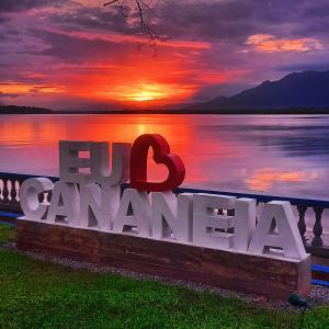 una señal para un lago con una puesta de sol en el fondo en Hotel Costa Azul, en Cananéia