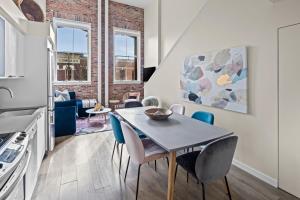 a kitchen and dining room with a table and chairs at Trendy 3 bedroom Loft in Chinatown with Parking! in Victoria