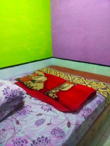 Una cama pequeña con una manta en una habitación en Penginapan sweety homestays, en Ciwidey