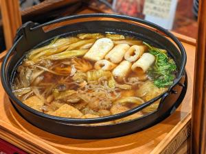 un tazón de sopa con fideos y otros alimentos en APA Hotel Akita-Senshukoen, en Akita