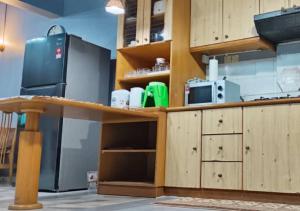 a kitchen with wooden cabinets and a counter top at 2BR Apartment in Port Dickson Bayu Beach Resort in Port Dickson