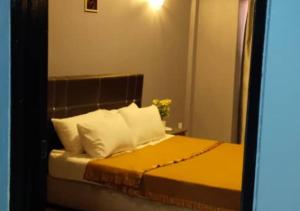 1 dormitorio con 1 cama con sábanas amarillas y almohadas blancas en 2BR Apartment in Port Dickson Bayu Beach Resort en Port Dickson