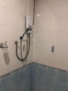 a shower in a bathroom with a hose on the wall at RT House in Chiang Mai