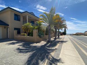uma casa com palmeiras ao lado de uma rua em Sunny Ocean View Retreat em Perth