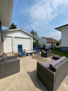 eine Terrasse mit zwei blauen Stühlen und einer Garage in der Unterkunft TheLux Den in Yorkton