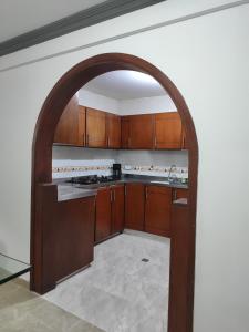 un arco en una cocina con armarios de madera en Apartamento, Casa en Buga - Valle, 
