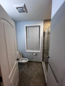 a bathroom with a toilet and a window at Private Studio in Providence