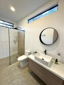 a bathroom with a sink and a toilet and a mirror at CASA PALMANOVA CON PISCINA EN LA MESA in La Mesa