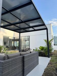 a glass extension of a house with a couch under awning at CASA PALMANOVA CON PISCINA EN LA MESA in La Mesa