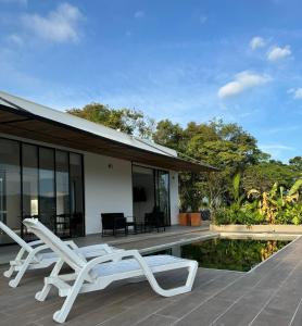 eine Villa mit einem Pool und 2 Liegestühlen in der Unterkunft CASA PALMANOVA CON PISCINA EN LA MESA in La Mesa