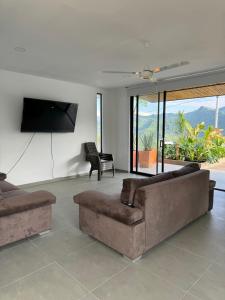 sala de estar con sofá y TV de pantalla plana en CASA PALMANOVA CON PISCINA EN LA MESA en La Mesa