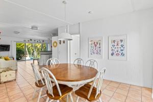 a kitchen and dining room with a wooden table and chairs at The Islander in Point Lookout