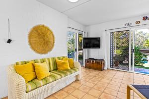 a living room with a couch with yellow pillows at The Islander in Point Lookout