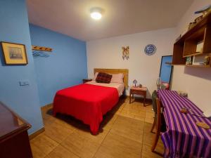 een slaapkamer met een bed met een rode deken bij Habitación con baño privado acceso a cocina y terraza en Miraflores in Lima
