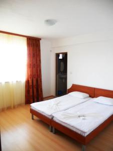 1 dormitorio con 1 cama grande con sábanas blancas en Marianas Guesthouse en Obzor