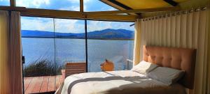 - une chambre avec un lit et une vue sur l'eau dans l'établissement Los Uros vista Ciudad Puno, à Puno