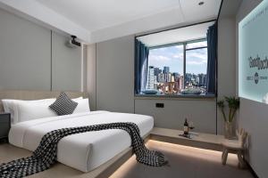 Un dormitorio con una gran cama blanca y una ventana en MuMu Hotel Changsha, en Changsha