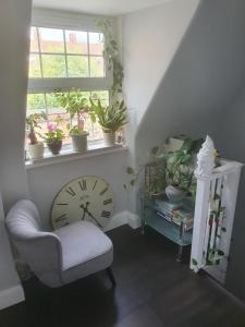 a room with a clock and a chair and a window at Goldsmith Rd in London