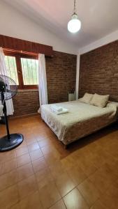 une chambre avec un lit et un mur de briques dans l'établissement Casa Rumipal, à Villa Rumipal