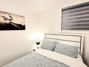 a bedroom with a bed and a picture on the wall at Somy Suite - Cozy 2bedrom with two queens bed and free street parking in Calgary
