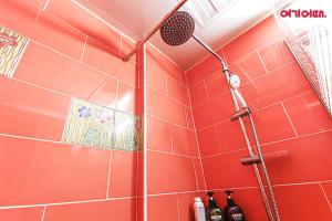 首爾的住宿－Coups Hotel，浴室铺有红色瓷砖,设有淋浴。