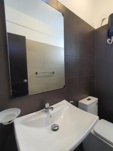 La salle de bains est pourvue d'un lavabo blanc et d'un miroir. dans l'établissement CoolView Colombo, à Colombo